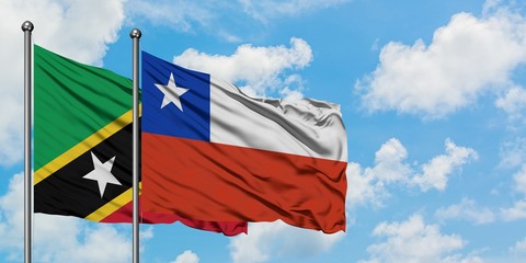 Saint Kitts And Nevis and Chile flag waving in the wind against white cloudy blue sky together. Diplomacy concept, international relations.