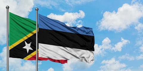 Saint Kitts And Nevis and Estonia flag waving in the wind against white cloudy blue sky together. Diplomacy concept, international relations.