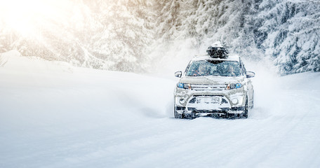 CORTINA D'AMPEZZO, ITALY - JANUARY 31, 2019: Winter roads in beatiful snowy forest. Snow calamity or blizzard on street. Fast modern suzuki Vitara car on snow road in storm. © Milan