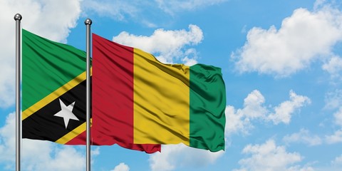 Saint Kitts And Nevis and Guinea flag waving in the wind against white cloudy blue sky together. Diplomacy concept, international relations.