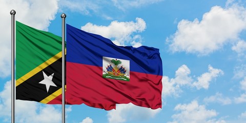 Saint Kitts And Nevis and Haiti flag waving in the wind against white cloudy blue sky together. Diplomacy concept, international relations.