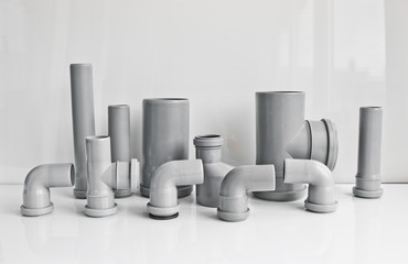 Plastic PVC pipes sewer fittings on a light background.