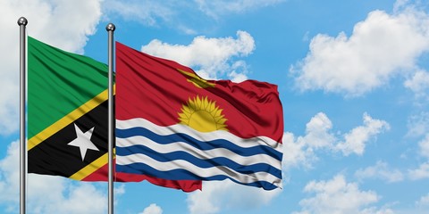 Saint Kitts And Nevis and Kiribati flag waving in the wind against white cloudy blue sky together. Diplomacy concept, international relations.