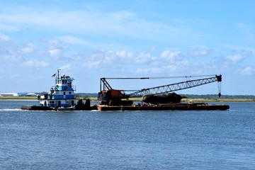 Tugboat towing a barge on the river at St. Augustine, Florida