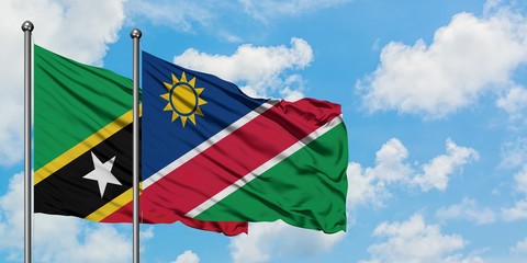 Saint Kitts And Nevis and Namibia flag waving in the wind against white cloudy blue sky together. Diplomacy concept, international relations.