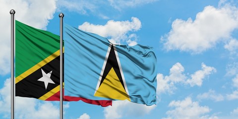 Saint Kitts And Nevis and Saint Lucia flag waving in the wind against white cloudy blue sky together. Diplomacy concept, international relations.