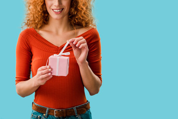 cropped view of smiling woman holding gift box isolated on blue