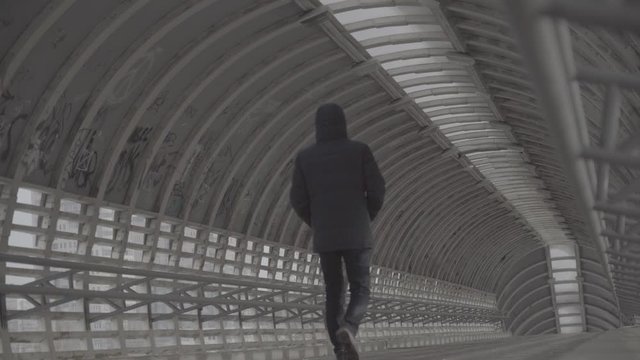 A man walks through the tunnel. Walking through a tunnell. s-log, ungraded. Video for post-processing. Ungraded slog 3 video material, no color correction.
