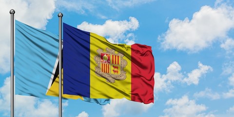 Saint Lucia and Andorra flag waving in the wind against white cloudy blue sky together. Diplomacy concept, international relations.
