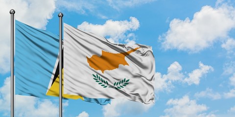 Saint Lucia and Cyprus flag waving in the wind against white cloudy blue sky together. Diplomacy concept, international relations.