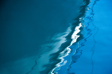 Boat reflection into water creates an abstract background.