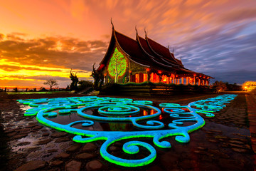 Obraz premium Amazing Temple Sirindhorn Wararam Phuproud in Ubon Ratchathani Province at twilight time,Thailand.Thai temple with grain and select white balance.Night sky effect for Long exposure fluorescent light.