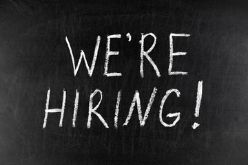 Obraz premium We`re Hired handwritten with white chalk on a blackboard