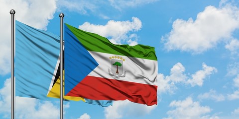 Saint Lucia and Equatorial Guinea flag waving in the wind against white cloudy blue sky together. Diplomacy concept, international relations.