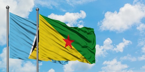 Saint Lucia and French Guiana flag waving in the wind against white cloudy blue sky together. Diplomacy concept, international relations.