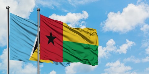 Saint Lucia and Guinea Bissau flag waving in the wind against white cloudy blue sky together. Diplomacy concept, international relations.