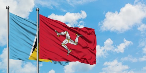 Saint Lucia and Isle Of Man flag waving in the wind against white cloudy blue sky together. Diplomacy concept, international relations.