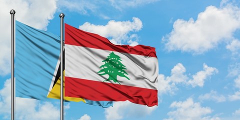 Saint Lucia and Lebanon flag waving in the wind against white cloudy blue sky together. Diplomacy concept, international relations.