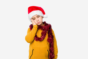 Little boy celebrating christmas day wearing a santa hat isolated who is bored, fatigued and need a relax day.