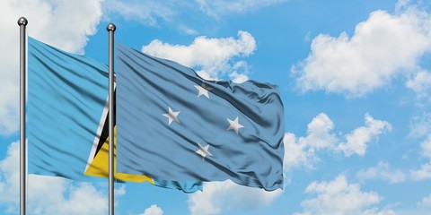Saint Lucia and Micronesia flag waving in the wind against white cloudy blue sky together. Diplomacy concept, international relations.