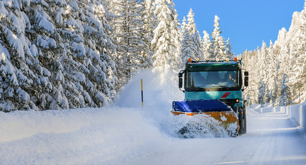 Sow plough truck removing fresh heavy snow from road in winter season. Maintenance cleaning vehicle.