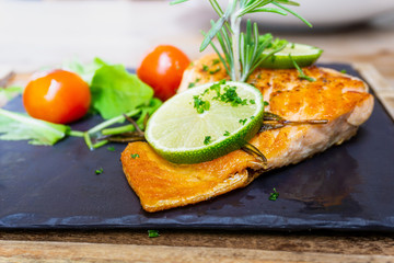 grilled salmon and lemon - french cuisine dish with tomato and salmon