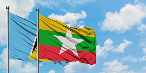 Saint Lucia and Myanmar flag waving in the wind against white cloudy blue sky together. Diplomacy concept, international relations.
