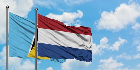 Saint Lucia and Netherlands flag waving in the wind against white cloudy blue sky together. Diplomacy concept, international relations.