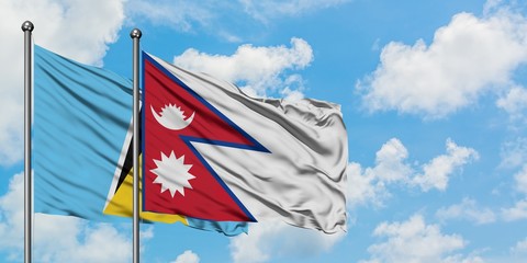Saint Lucia and Nepal flag waving in the wind against white cloudy blue sky together. Diplomacy concept, international relations.
