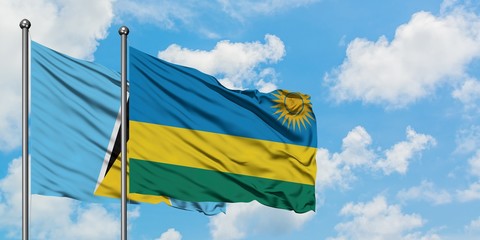 Saint Lucia and Rwanda flag waving in the wind against white cloudy blue sky together. Diplomacy concept, international relations.