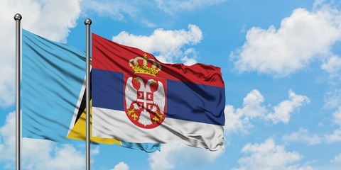 Saint Lucia and Serbia flag waving in the wind against white cloudy blue sky together. Diplomacy concept, international relations.