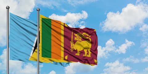 Saint Lucia and Sri Lanka flag waving in the wind against white cloudy blue sky together. Diplomacy concept, international relations.