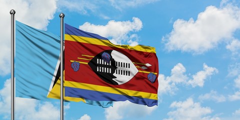 Saint Lucia and Swaziland flag waving in the wind against white cloudy blue sky together. Diplomacy concept, international relations.