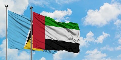 Saint Lucia and United Arab Emirates flag waving in the wind against white cloudy blue sky together. Diplomacy concept, international relations.