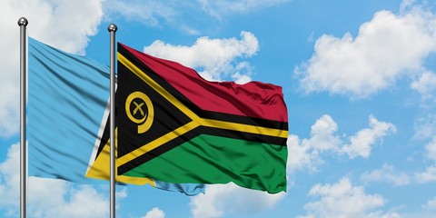 Saint Lucia and Vanuatu flag waving in the wind against white cloudy blue sky together. Diplomacy concept, international relations.