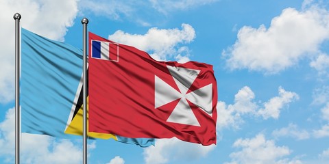 Saint Lucia and Wallis And Futuna flag waving in the wind against white cloudy blue sky together. Diplomacy concept, international relations.