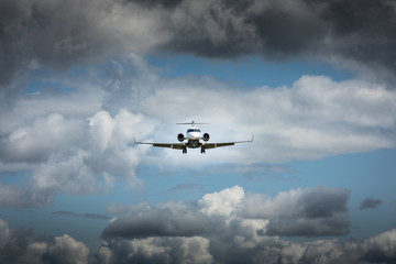 Fototapeta na wymiar Jet airplane flying in the cloudy skies