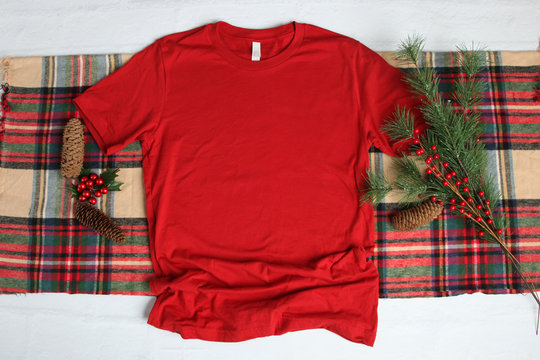 Flat lay mock-up of red t-shirt with Christmas holiday accessories