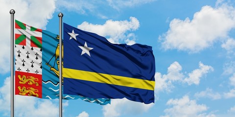 Saint Pierre And Miquelon and Curacao flag waving in the wind against white cloudy blue sky together. Diplomacy concept, international relations.