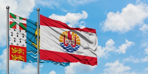 Saint Pierre And Miquelon and French Polynesia flag waving in the wind against white cloudy blue sky together. Diplomacy concept, international relations.