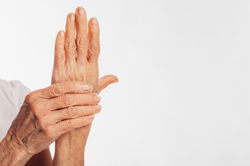 Picture of old hands with cream on them. Take care about fingers and nails. Cut view. Isolated over white background.