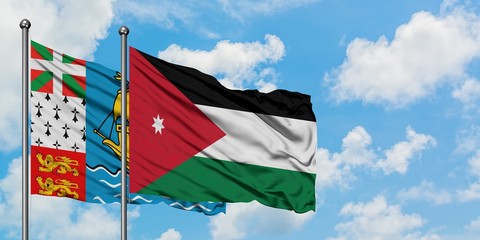 Saint Pierre And Miquelon and Jordan flag waving in the wind against white cloudy blue sky together. Diplomacy concept, international relations.