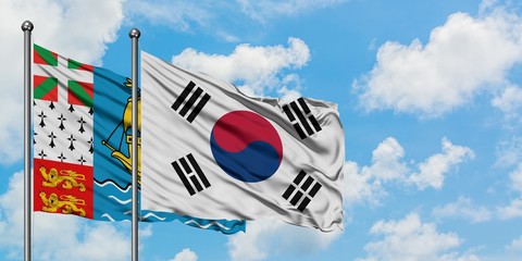 Saint Pierre And Miquelon and South Korea flag waving in the wind against white cloudy blue sky together. Diplomacy concept, international relations.