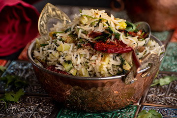 Indian rice pilaf served in traditional copper bowl
