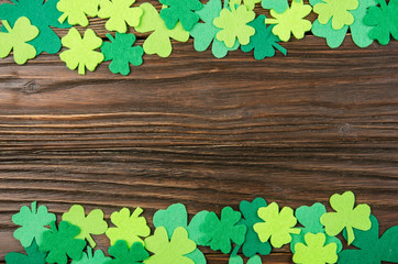 Happy Saint Patrick's mockup of handmade felt shamrock clover leaves on wooden background.