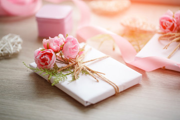 Composition with gift boxes decorated with green branch and rose.