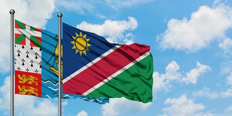 Saint Pierre And Miquelon and Namibia flag waving in the wind against white cloudy blue sky together. Diplomacy concept, international relations.