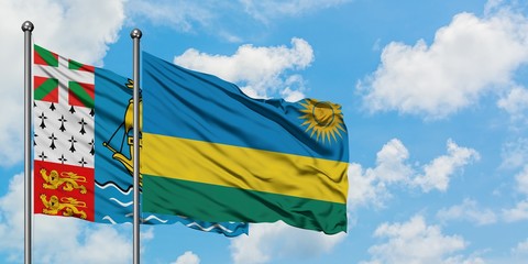 Saint Pierre And Miquelon and Rwanda flag waving in the wind against white cloudy blue sky together. Diplomacy concept, international relations.