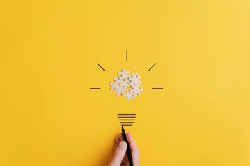 Tuinposter Light bulb over yellow background in vision and idea conceptual image © Gajus