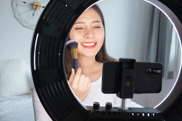 Portrait of young asian woman review giveaway gift product fan following channel, recording video make up lipstic cosmetic at home. Beauty blogger present beauty cosmetics